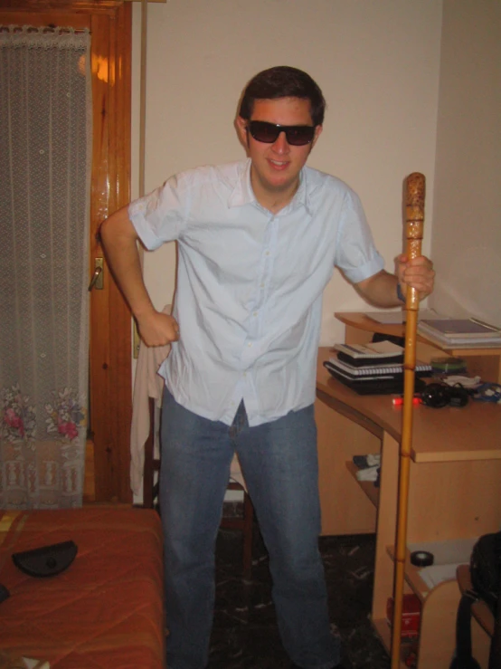 a man holding a bat wearing sunglasses and pointing at soing