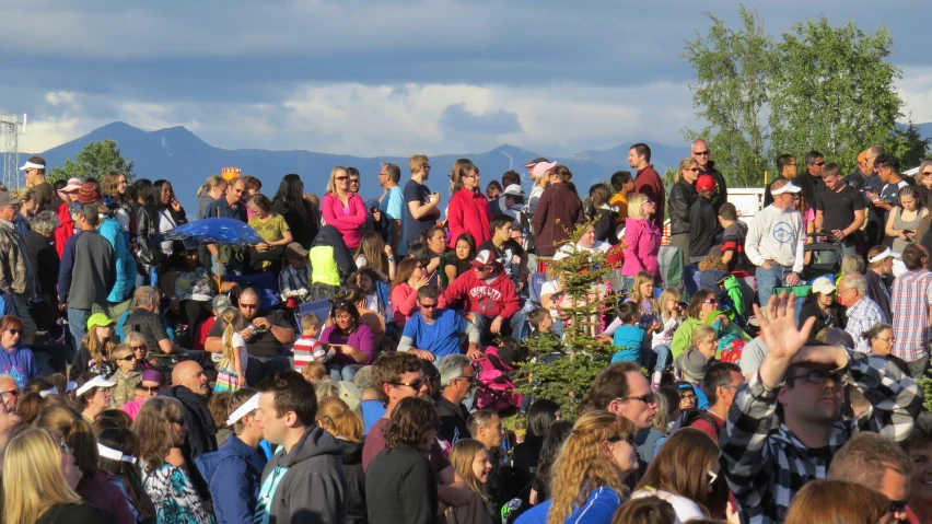 large crowd of people at outdoor event in mountains