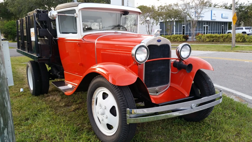 an old orange car is parked in the grass