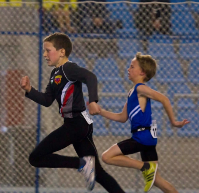 a  running on a track next to another runner