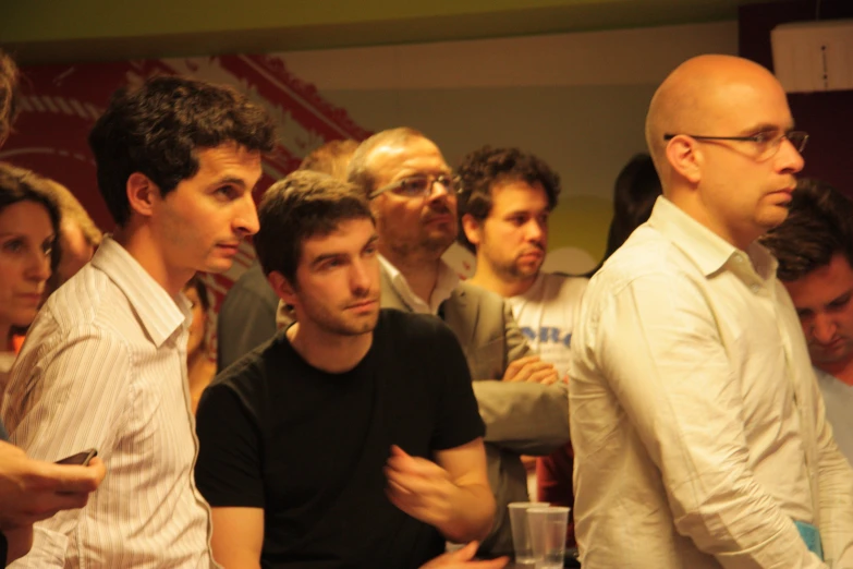 a group of men sitting next to each other near a window