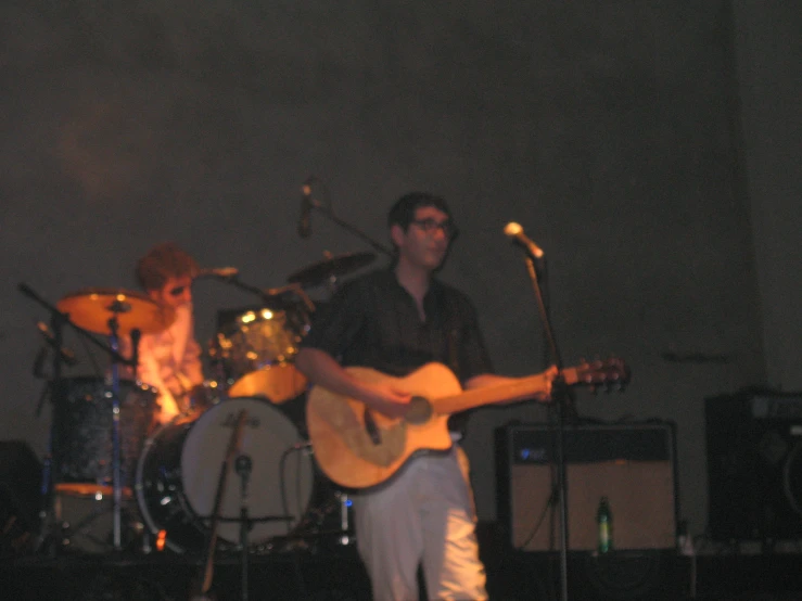 two men playing guitars in a music room