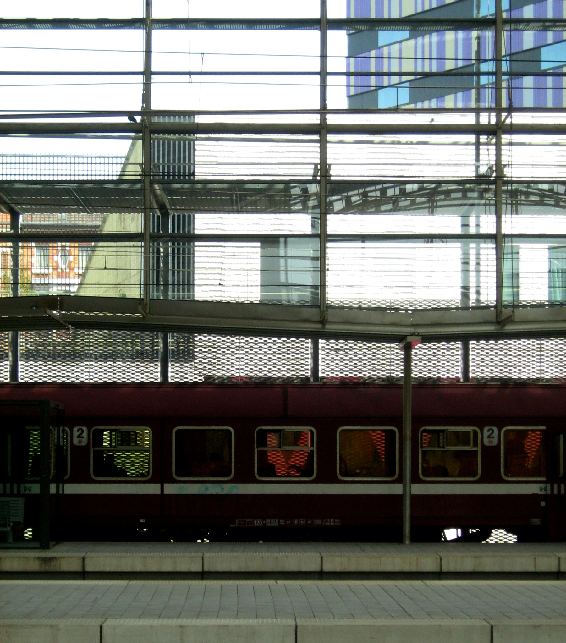 a train driving under an overpass with multiple windows