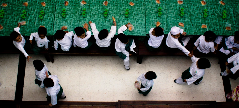 some girls are sitting and playing on a bench