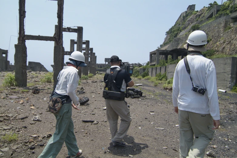 three men on the side of a road near a cliff