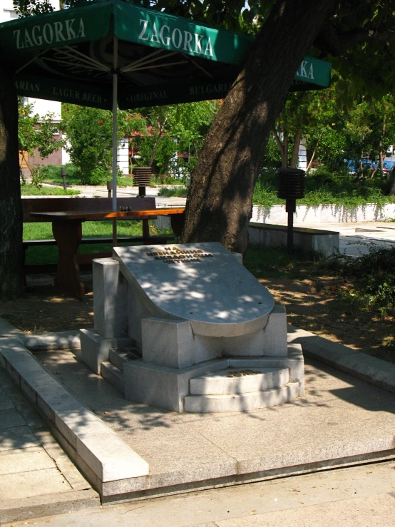 park with stone bench under shade shelter on sunny day