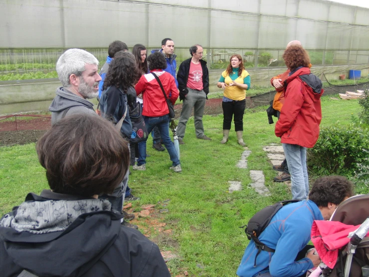 the group of people are standing in a garden