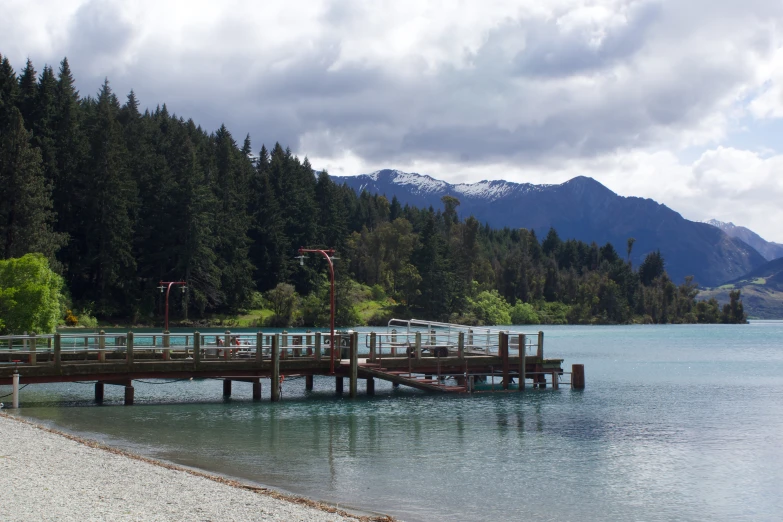 a pier next to a lake with a mountain in the background