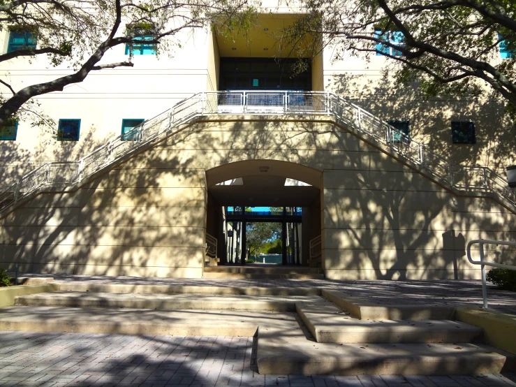 a large building with steps and trees in front