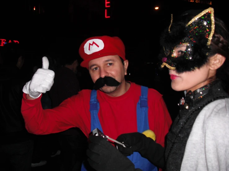 a man is dressed as mario and an emotem costume