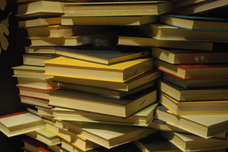 lots of books stacked together on a desk