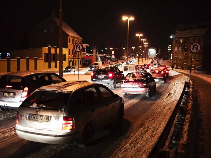 a bunch of cars driving down the road at night