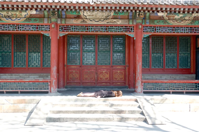 a woman sitting on steps near a building