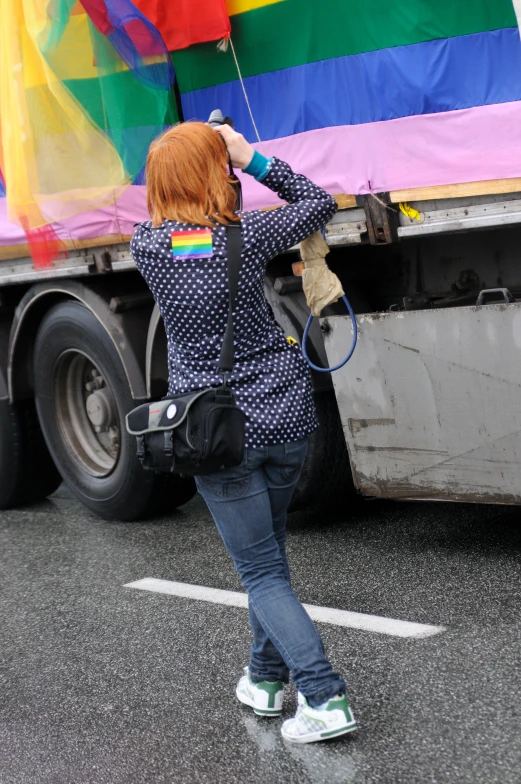 a woman is walking with a large colorful kite