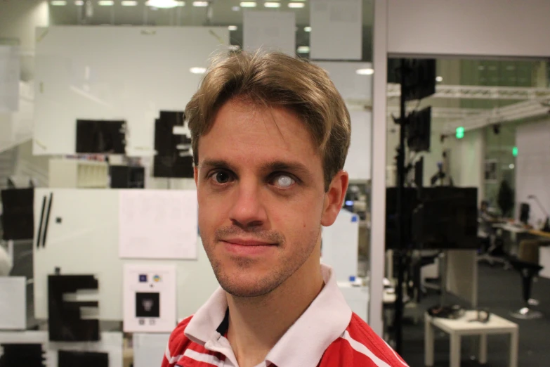 a man poses for a picture in an office