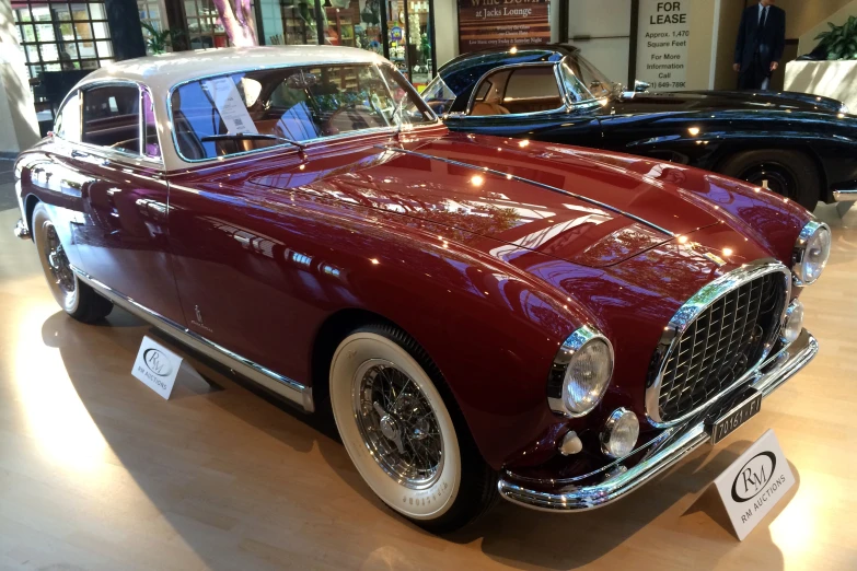 an old fashioned red car sitting on display