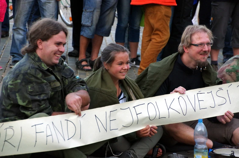 a man and woman hold a protest sign