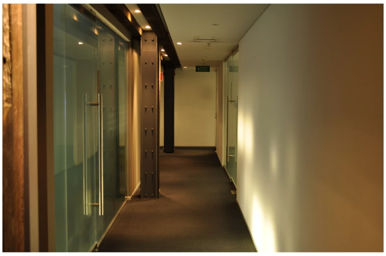 a long corridor with glass partitions and a wooden ceiling