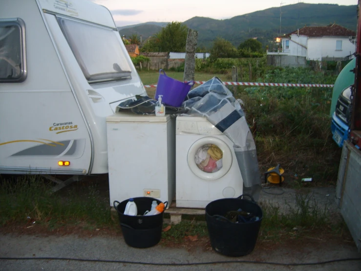 a white washer sitting next to two buckets