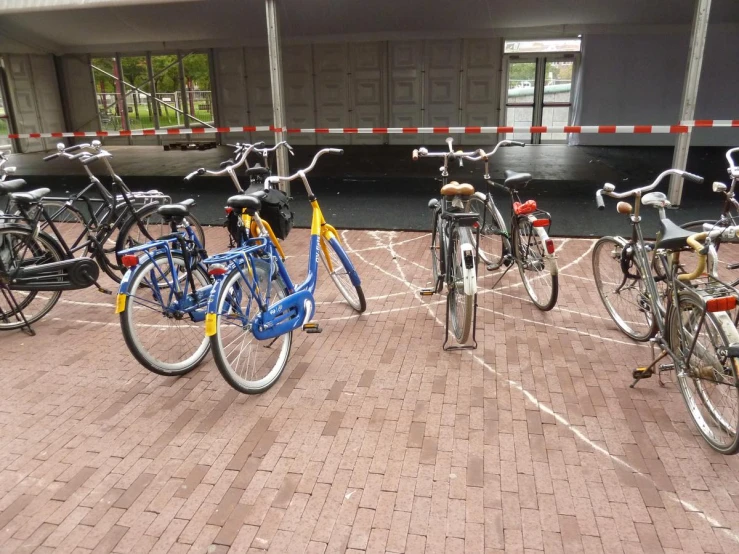 multiple bikes sit in a row on the pavement