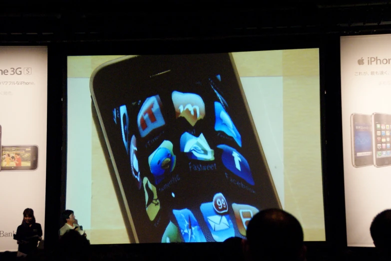 a display of cell phones on a wall at an apple event