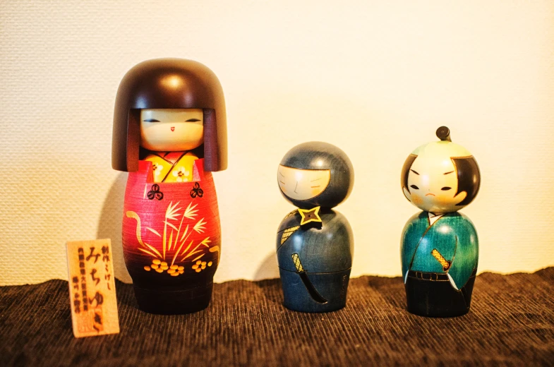three colorful dolls with asian writing on them