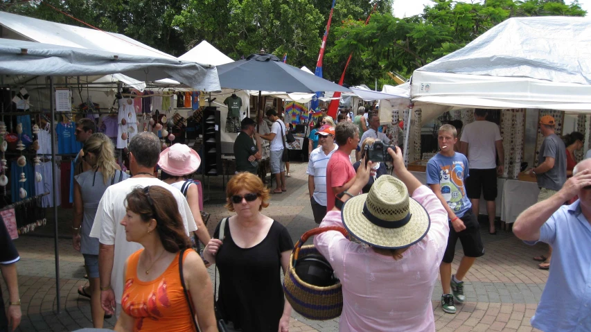 people gather in front of open tents while taking pictures