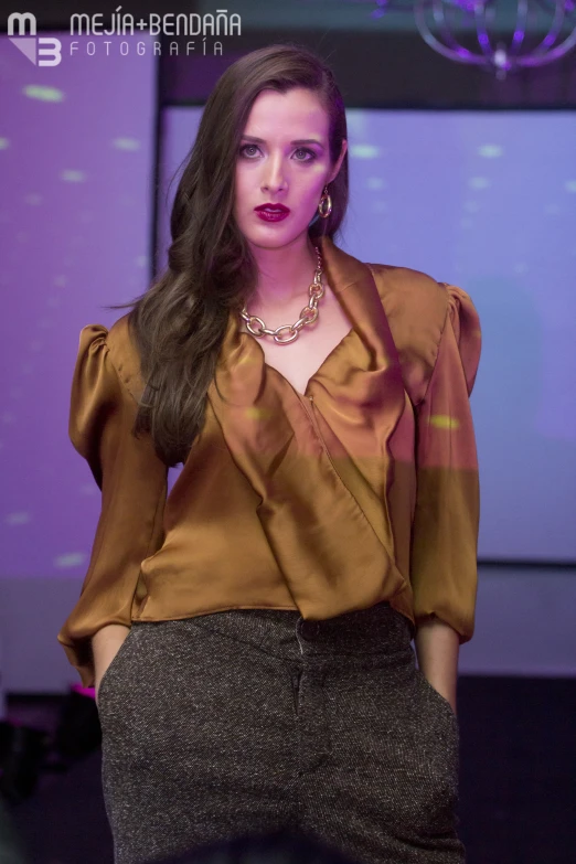 a woman walks down a runway at a fashion show