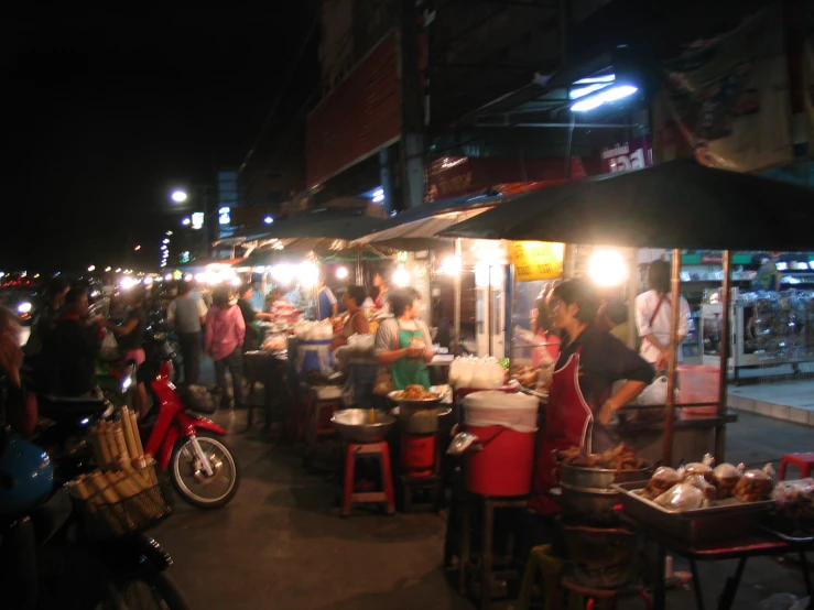 people standing and sitting at tables in front of some building