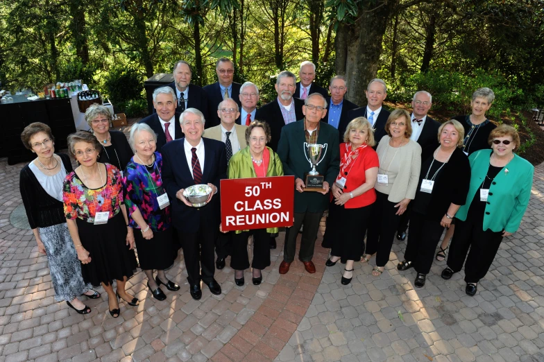 a group of people standing around each other with a banner