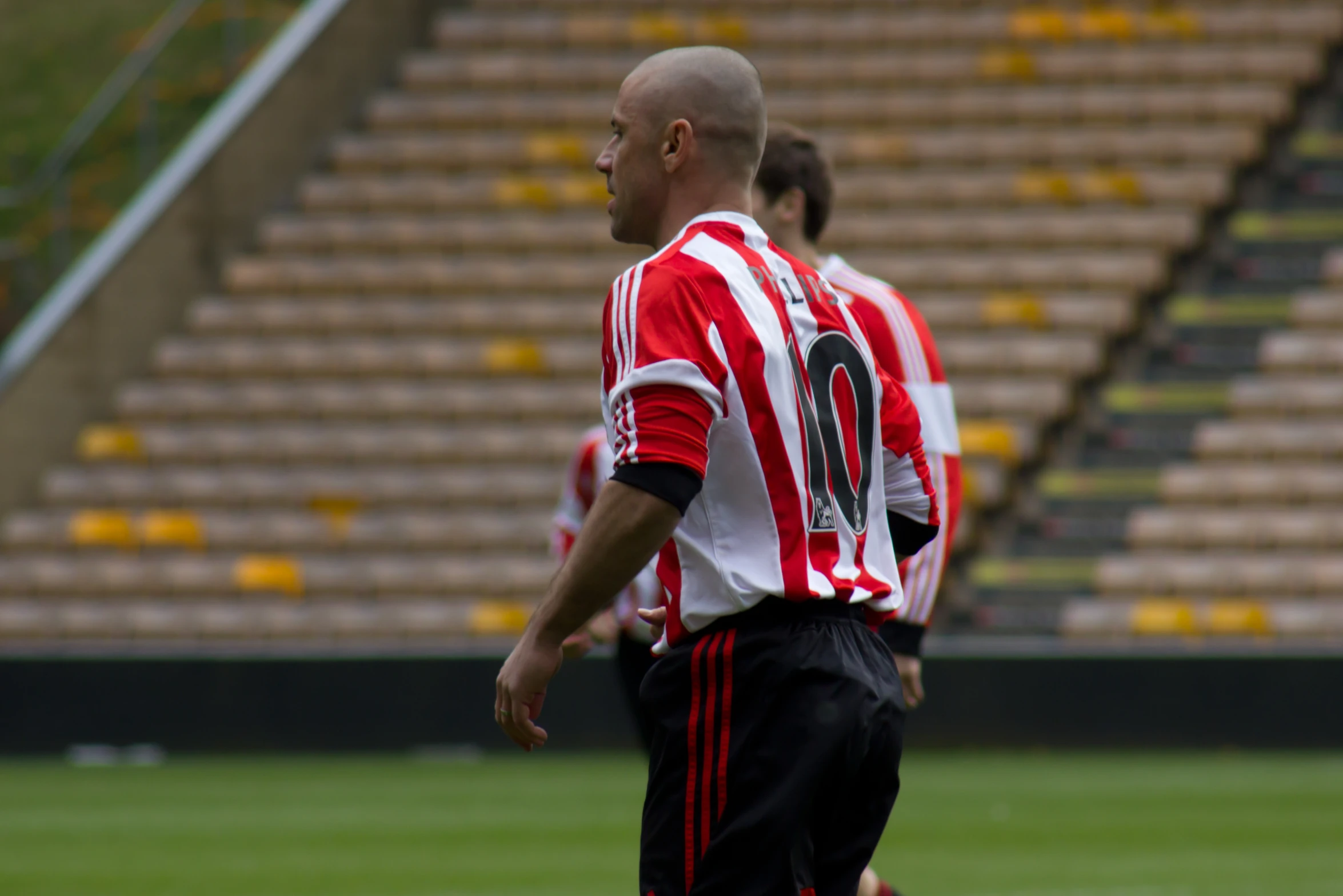 a male in a soccer uniform walking by the goalie