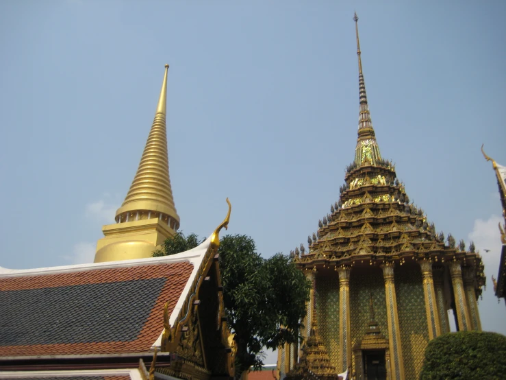 a tall golden building near a golden domed structure