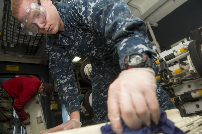 a man in uniform  soing with a blue cloth