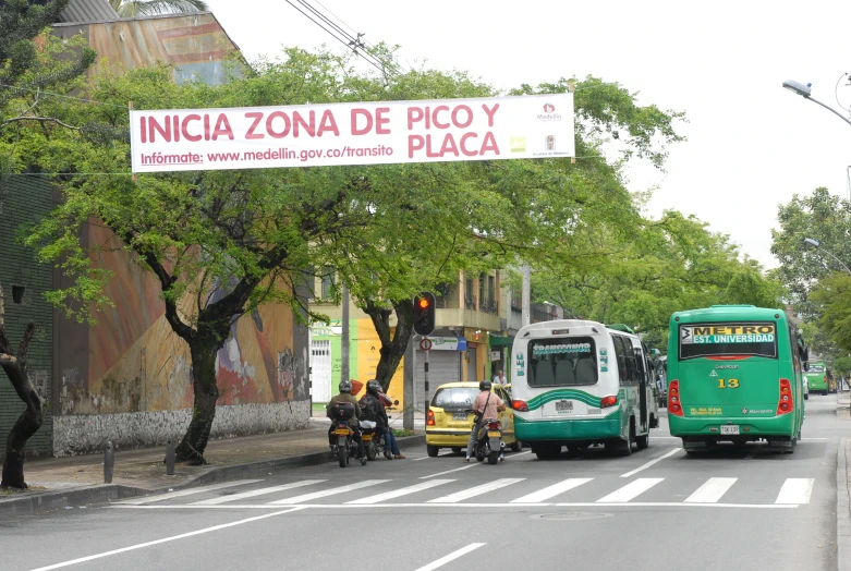 people are sitting at the street corner next to a bus