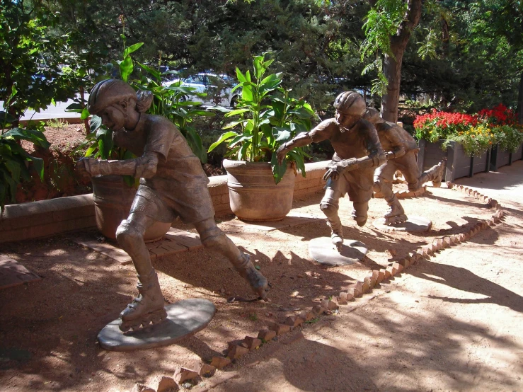some statues are playing baseball in a park