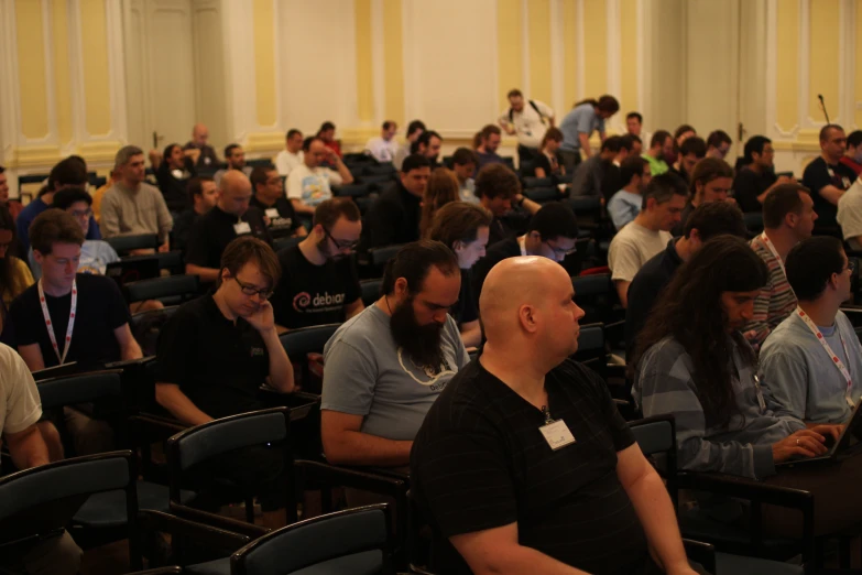 a bunch of people are sitting in rows on their computers