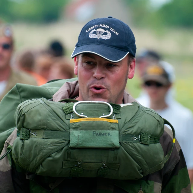 man in a camouflage jacket wearing an army hat