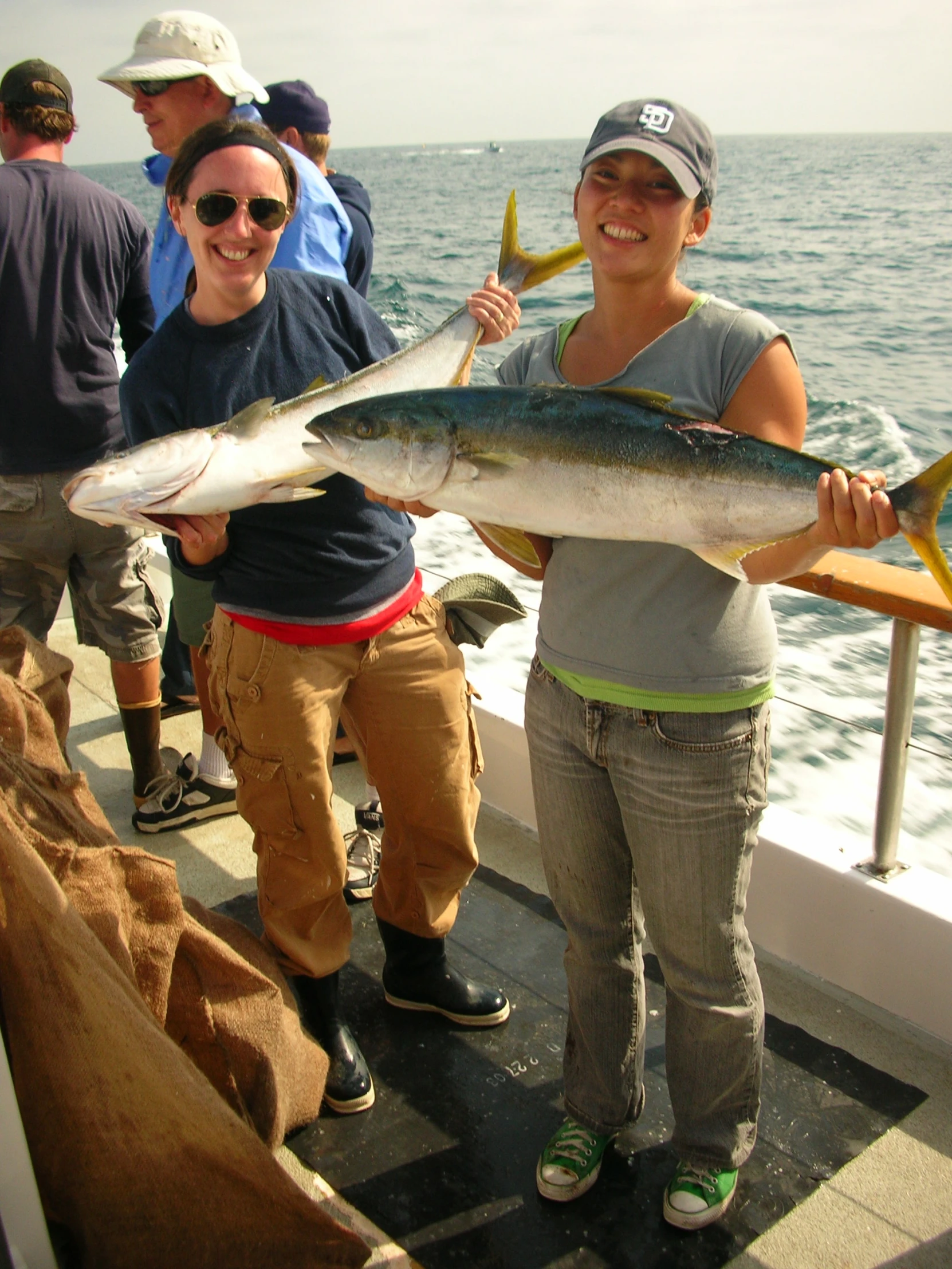 a woman holding a fish while other people watch