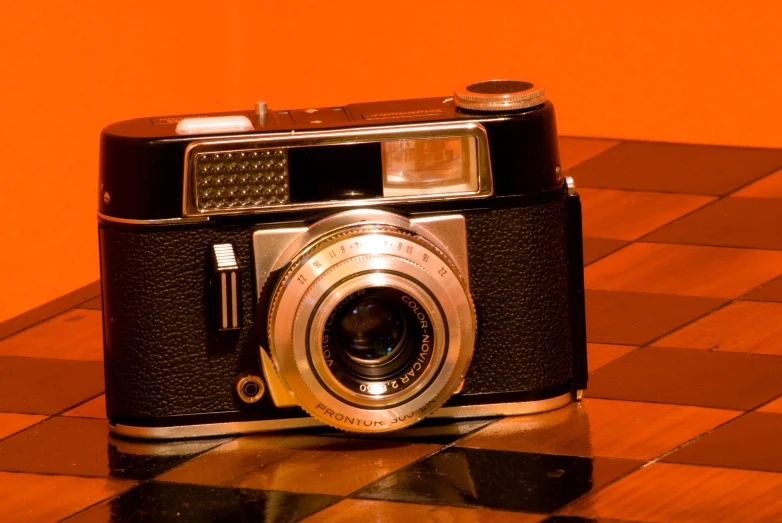 a very old camera on a checkered floor