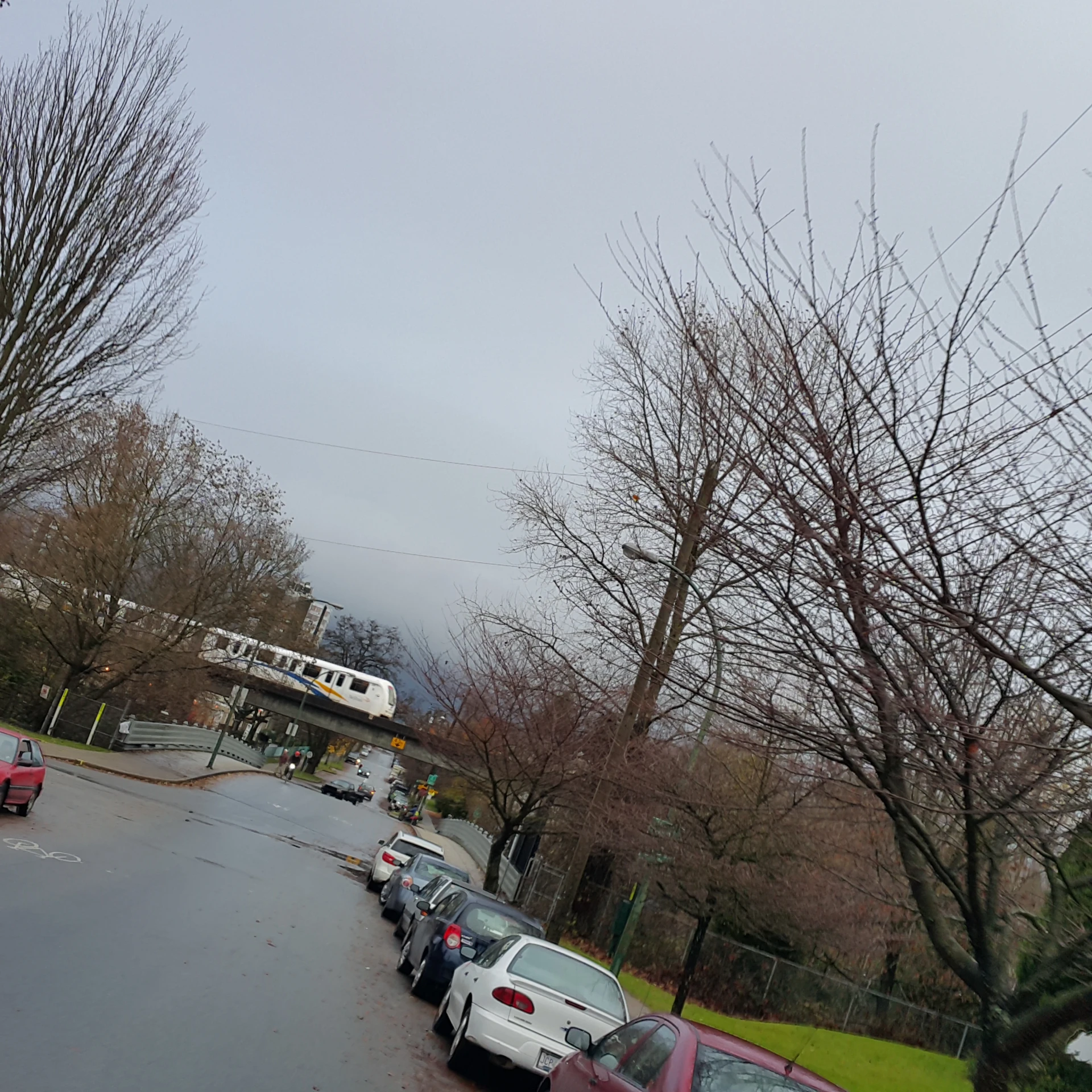 cars on a street line with a train on top