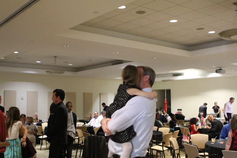 man and woman hugging each other in a ballroom