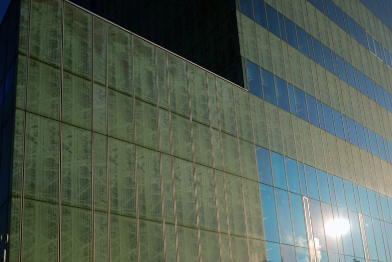 a tall glass and metal building next to another glass building