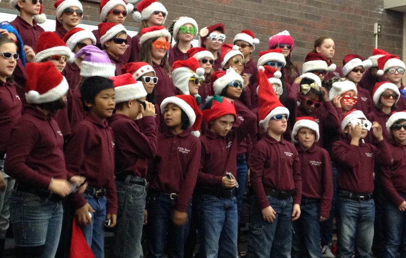 a group of young children wearing santa hats