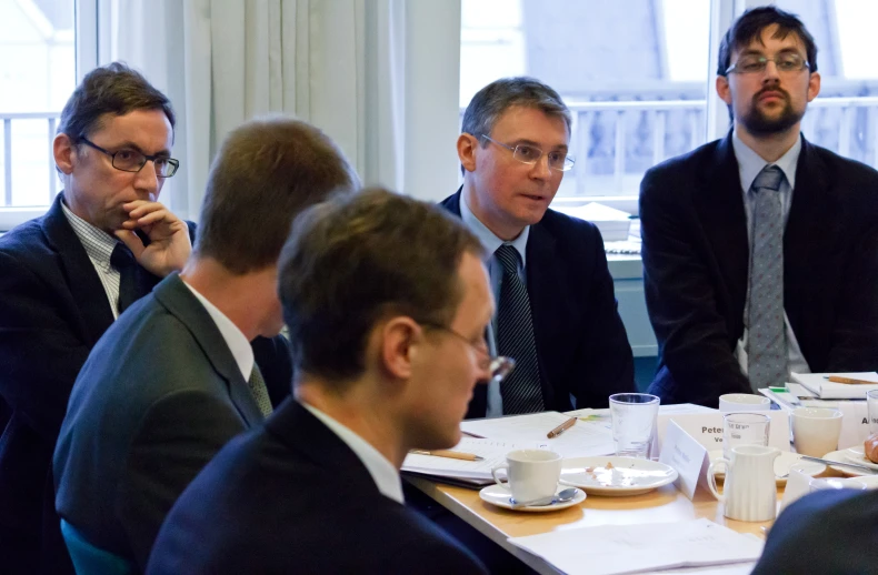 several people sit at a table together at an event