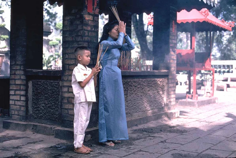 a woman holding onto a child on a sidewalk