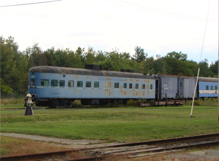 the blue train is waiting on tracks for its next stop