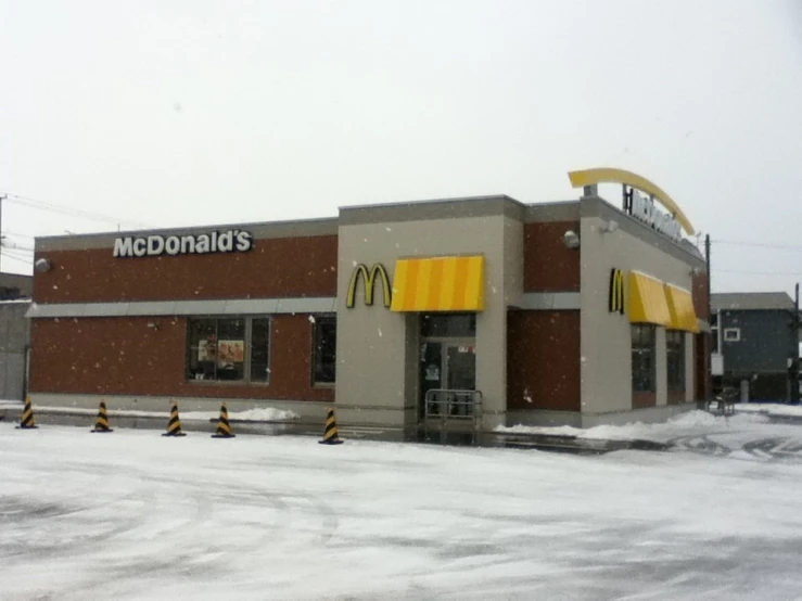 a mcdonalds restaurant on a snowy day with a sky background