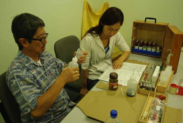 an asian couple are preparing drinks in their study room