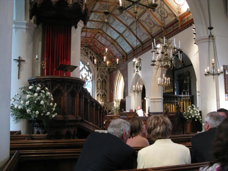 people watching a person give a speech from the back of a pew