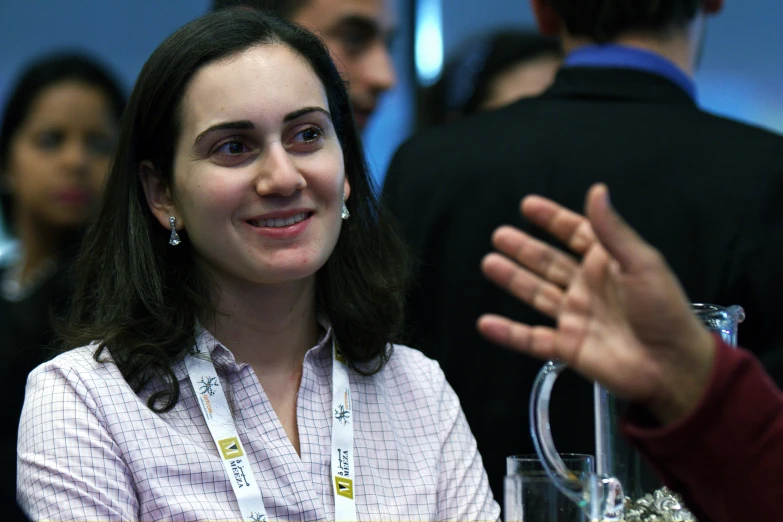 a woman is smiling and clapping for her fellow